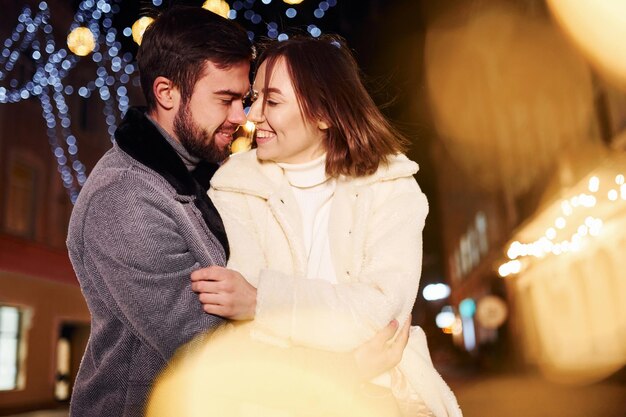 Abbracciarsi Felice giovane coppia festeggia il nuovo anno all'aperto sulla strada