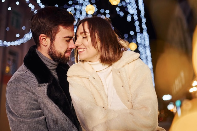 Abbracciarsi Felice giovane coppia festeggia il nuovo anno all'aperto sulla strada