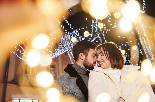 Abbracciarsi Felice giovane coppia festeggia il nuovo anno all'aperto sulla strada