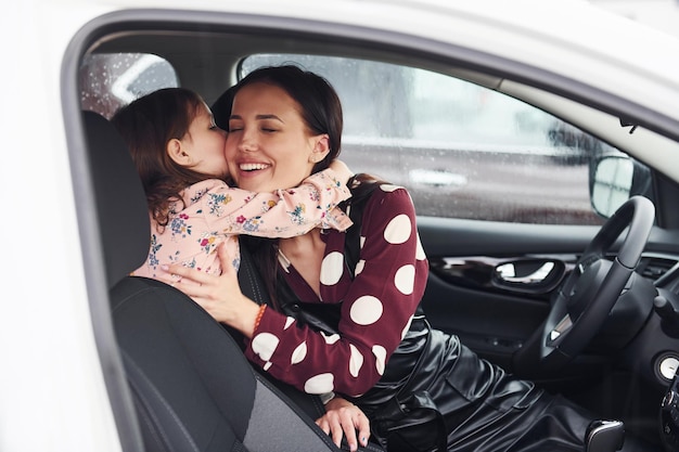 Abbracciarsi Madre con sua figlia dentro l'automobile moderna insieme