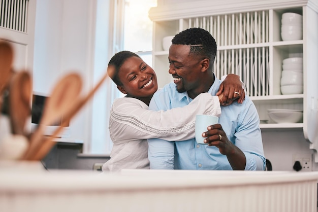 Abbraccio al caffè o felice coppia nera in cucina che parla o ride per rilassarsi con amore o cura a casa Sorridi mattina o uomo africano che parla a una donna con una bevanda del tè che lega insieme in una conversazione