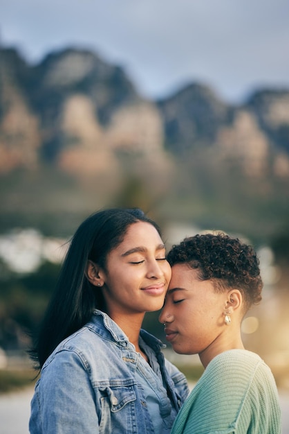 Abbraccio all'aperto e coppia queer con amore matrimonio e felicità con lesbiche romantiche e relazione Lgbtq donne o donne in vacanza e tempo di qualità con tramonto e abbraccio