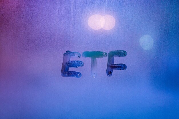 Abbreviazione parola etf exchange scambiati fondi scritti a mano su una finestra di vetro nebbiosa di notte con luce di strada sul retro blu neon