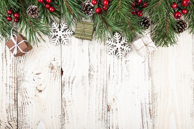 Abete con decorazioni natalizie e scatole regalo su fondo in legno