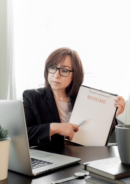 Abile donna di mezza età che comunica online, studia a distanza o lavora nell'ufficio di reclutamento.