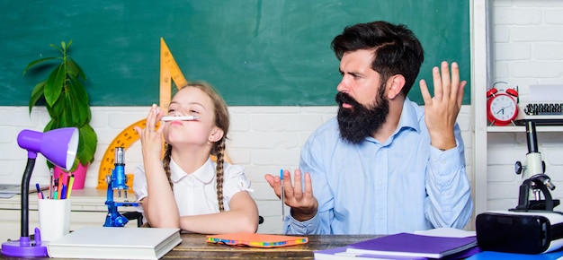 Abilità di pedagogia Pedagoga di talento Collaborare per ottenere di più Spiegare la scienza al bambino Lezione affascinante Insegnante di scuola e studentessa Insegnante uomo con la barba pedagogo eccellente