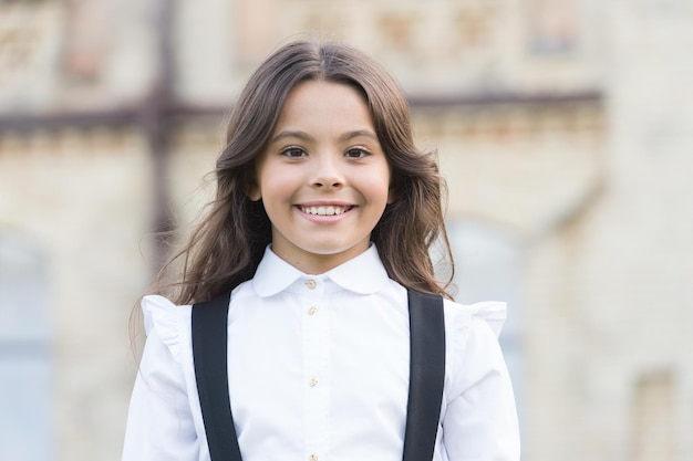 Abiti che sorridono. felice bellezza all'aperto. moda e shopping per bambini. buona giornata dei bambini. è tempo di primavera. aspetto elegante della scolaretta. uniforme da bambino retrò. allievo in abito vintage. di nuovo a scuola.