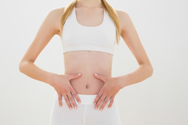 Abiti sportivi d&#39;uso della donna sportiva che toccano la sua pancia