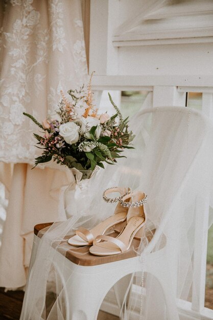 Abito da sposa fiori e scarpe su una sedia fuori