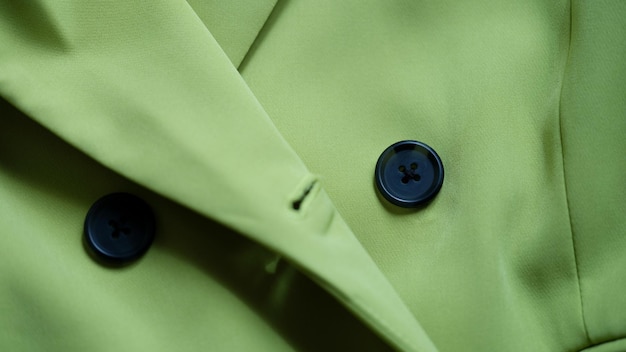 Abito elegante verde con bottoni neri in primo piano