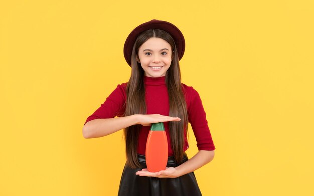 Abitudini quotidiane e pubblicità per la cura personale ragazza felice con lo shampoo della tenuta del cappello