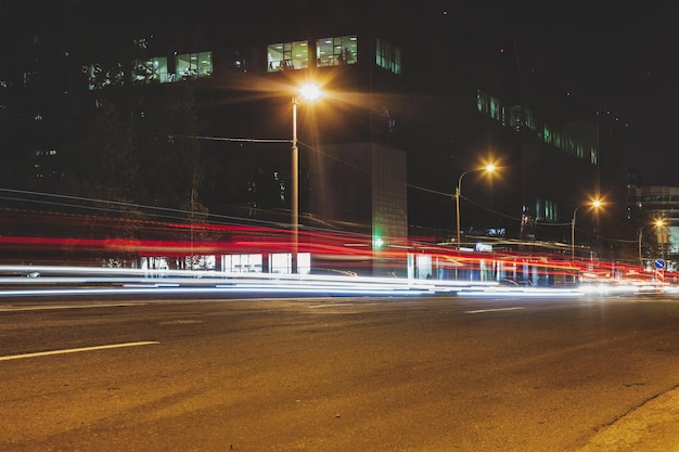 Abstract motion blur sullo sfondo della strada di notte con auto e lampioni. Vita di città, luci dal paesaggio urbano, tonalità di colore di stile. Concetto di sfondi urbani eleganti astratti per il design. Copia spazio