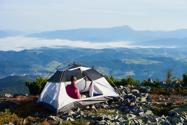 Accampandosi sulla cima della montagna sulla mattina luminosa dell'estate