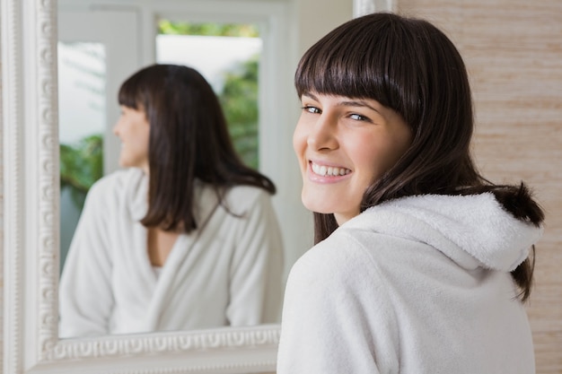 Accappatoio bianco da portare della bella giovane donna nel bagno