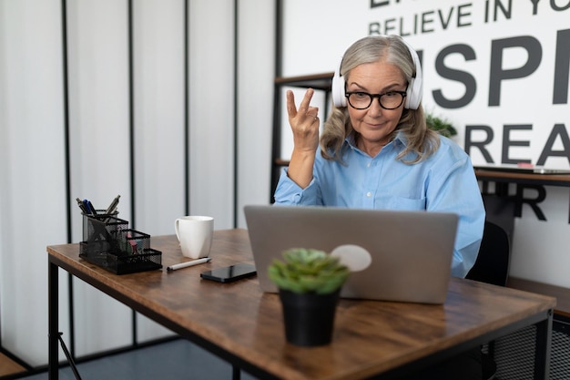 Accattivante donna adulta che parla al telefono con una tazza di caffè in mano