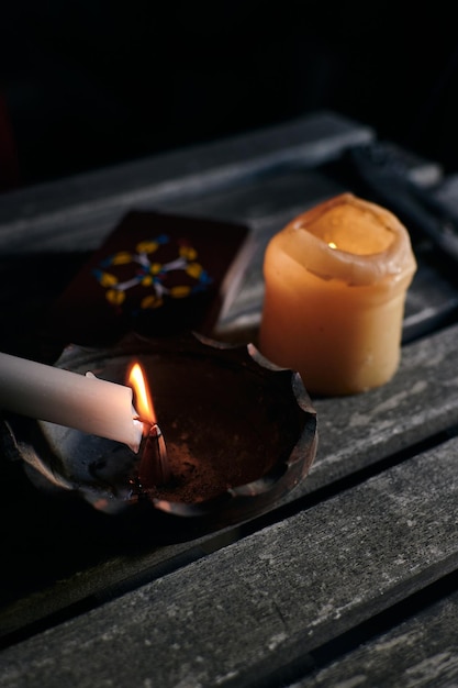 Accendere l'incenso con una candela con i tarocchi sul tavolo