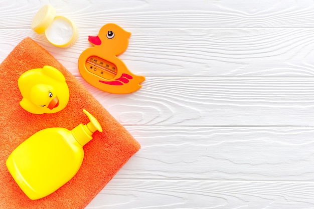 Accessori da bagno per bambini Shampoo crema asciugamano anatra di gomma gialla su legno bianco