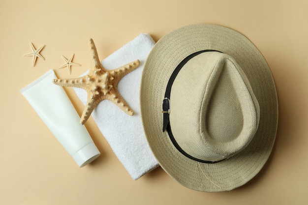 Accessori da mare e crema solare su beige