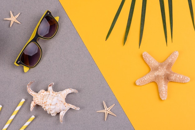 accessori da spiaggia e stelle marine su una superficie colorata