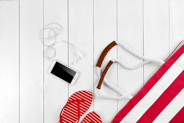 Accessori da spiaggia e telefono su fondo di legno