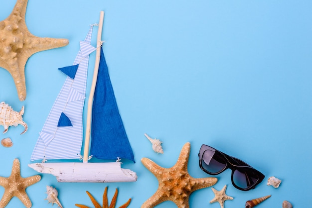 Accessori da spiaggia: occhiali con conchiglie e stelle marine. Sfondo estivo