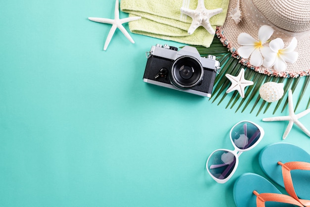 Accessori da spiaggia su pastello verde per il concetto di vacanza estiva.