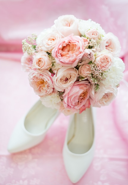 Accessori da sposa per il giorno del matrimonio di lusso. Concetto di matrimonio. Matrimonio e anello di fidanzamento vicino a scarpe con i tacchi alti, gioielli per la sposa e bouquet di fiori