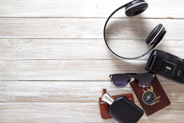 Accessori da viaggio per viaggio estivo su legno bianco nero