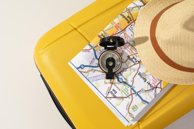 Accessori da viaggio su bussola gialla per cappello bagmap