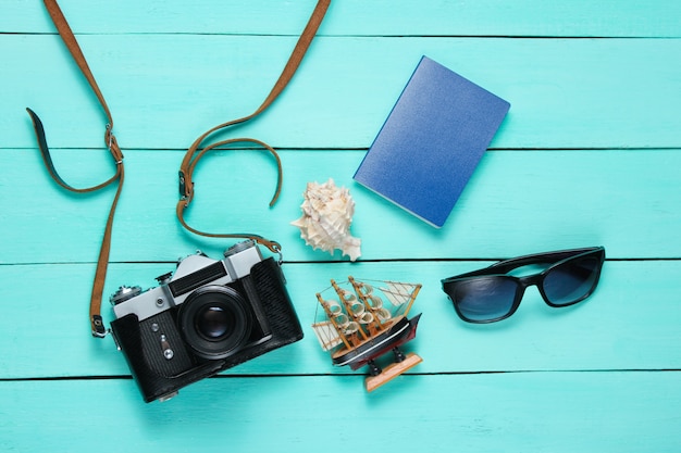 Accessori del viaggiatore, retro macchina fotografica su legno blu. Lay piatto