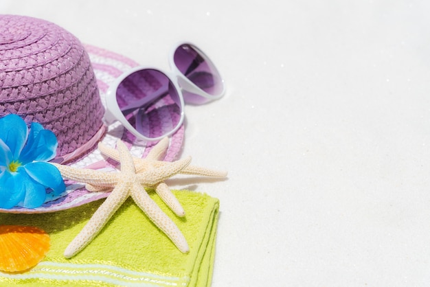 Accessori della spiaggia sul fondo bianco della spiaggia sabbiosa per estate