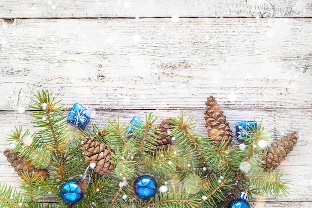 Accessori di Natale in rami di abete e blu su fondo di legno