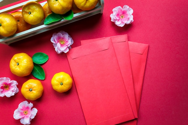 Accessori di vista superiore Decorazioni cinesi del nuovo anno festival, foglia, cestino di legno, pacchetto rosso, fiore di prugne su sfondo rosso.