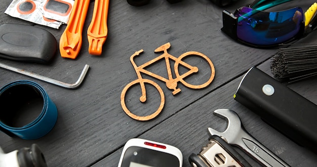 Accessori differenti della bicicletta sulla tavola di legno