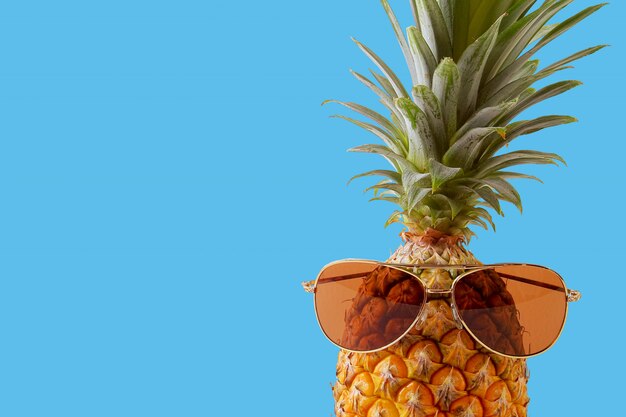 Accessori e frutta di modo dell&#39;ananas dei pantaloni a vita bassa su fondo blu