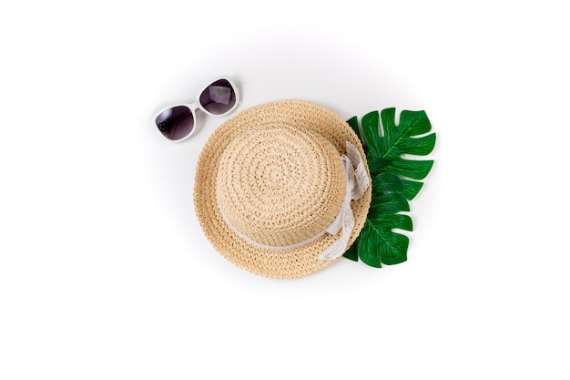 Accessori estivi femminili cappello di paglia, occhiali da sole e foglie di palma verdi