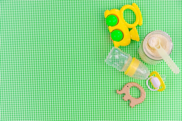 Accessori per bambini e cibo su uno sfondo verde. Messa a fuoco selettiva.baby