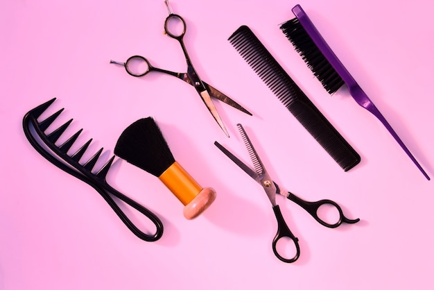 Accessori vari di parrucchiere su una superficie rosa