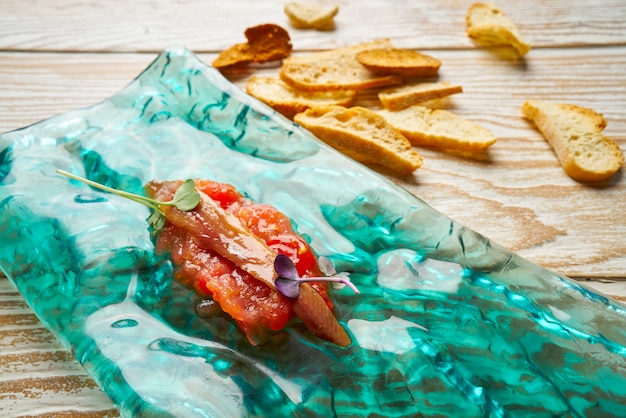 Acciughe su tapas di pomodoro fresco grattugiato