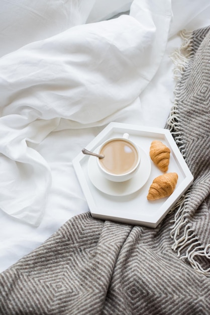 Accogliente colazione a letto tazza di caffè e croissant