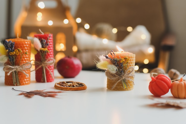 Accogliente composizione autunnale con candele e foglie di cera di zucca