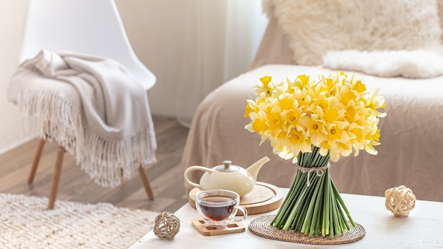 Accogliente natura morta con fiori primaverili all'interno luminoso soggiorno. Il concetto di arredamento e comfort.