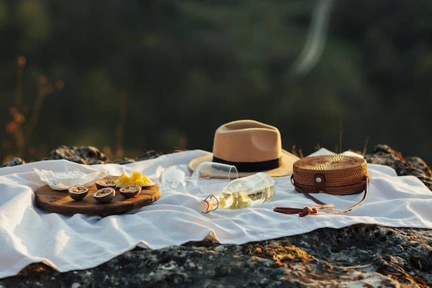 Accogliente picnic con un delizioso brie di formaggio fresco ai frutti tropicali e vino sulla tovaglia bianca a