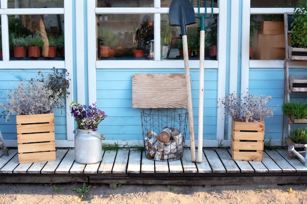 Accogliente veranda con decorazioni autunnali. Portico in legno della casa con piante, tronchi.