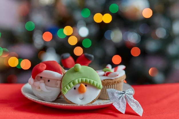 Accoglienti cupcakes di Natale Cupcake creativi decorativi davanti all'albero di Natale Vacanze festive di buon umore Messa a fuoco selettiva