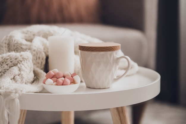 Accoglienti decorazioni per la casa all'interno con lavoro a maglia e tazza di tè nel soggiorno