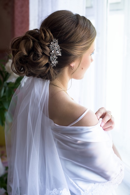 Acconciatura da sposa. sposa. vista laterale. mattina della sposa