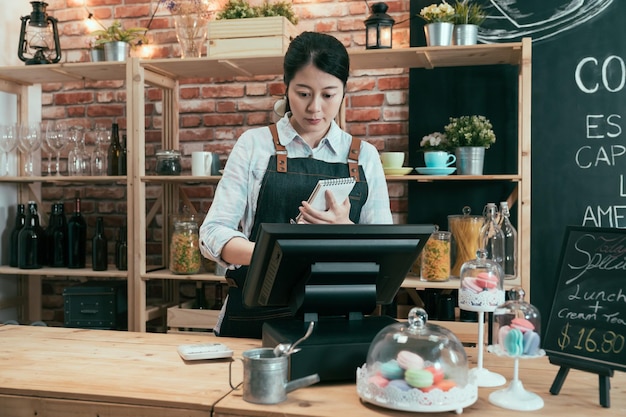 account di rendering di donna cinese asiatica con punto di accesso della macchina terminale di vendita nella caffetteria. elegante cameriera femminile in grembiule che tiene nota dell'ordine del cliente e tocca il registratore di cassa nella caffetteria