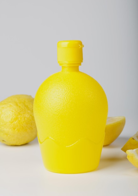 Acido citrico liquido in una bottiglia di plastica e pezzi di limone fresco. Avvicinamento