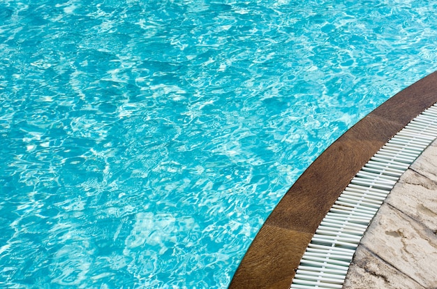 Acqua blu della piscina con riflessi del sole